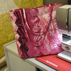 Brandy Maslowski - Hexi Market bag in deep pinks - sitting beside sewing machine