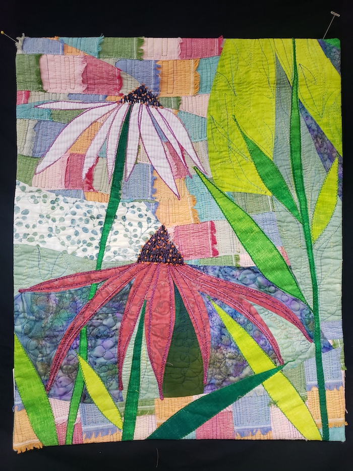 Two appliquéd cone flowers on multi color background