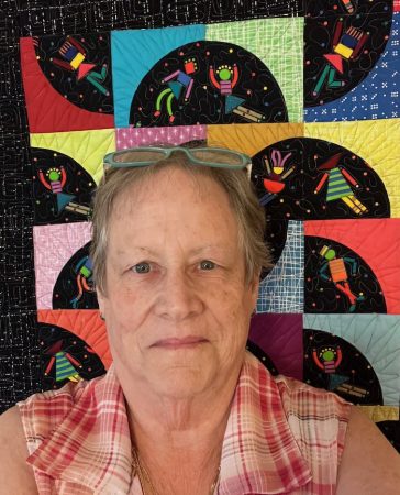 person with a quilt behind